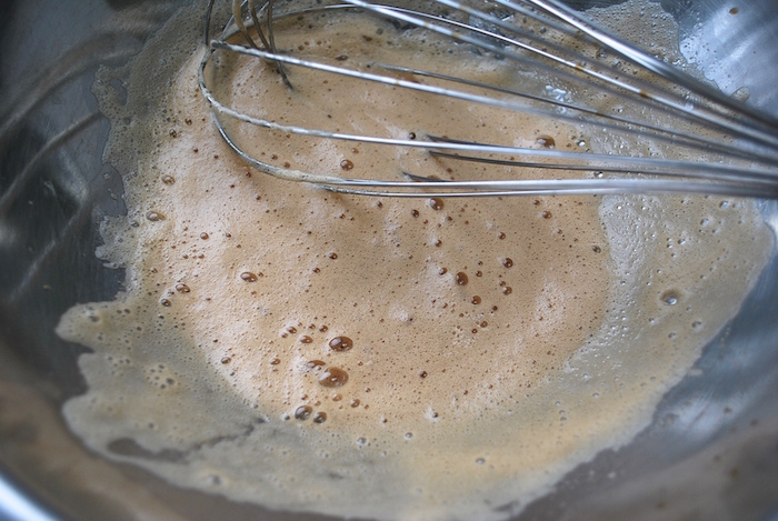 Whisking the egg white and vanilla until frothy.