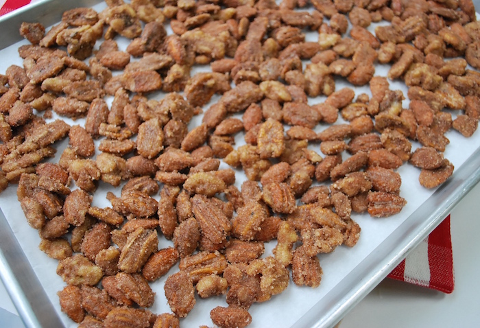 The nuts are spread in a single layer on a baking sheet.