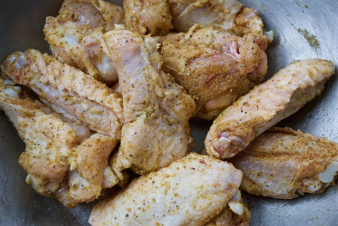 Raw coated crack wings in a bowl.