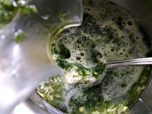 Pouring cilantro water into pan with rice.
