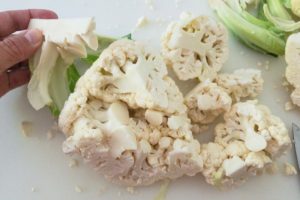 Removing core from quartered cauliflower.