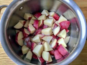Cubed red potatoes in pot sprinkled with salt.
