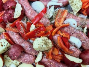 Seasonings are added to the sausage, potatoes, peppers, and onions.