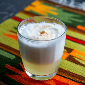 A glass of Peruvian pisco sour on a Peruvian placemat.