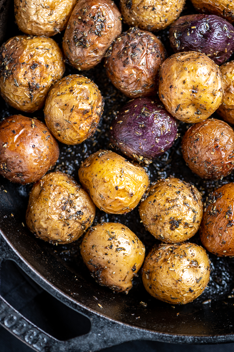 Roasted baby potatoes with rosemary and thyme in a cast iron skillet.
