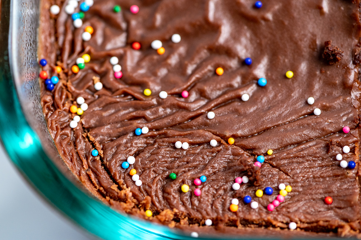 A closeup of chocolate icing with sprinkles.