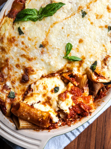 Baked rigatoni with three cheeses in a casserole dish.