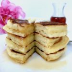 Stack of pancakes on a plate with syrup.