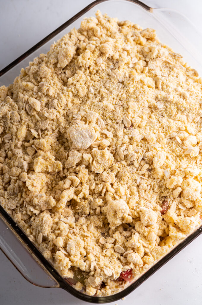 A square pan of crisp topped with unbaked oat topping.