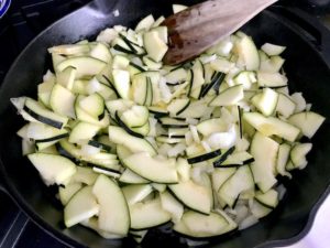 Sautéing zucchini in a skillet.
