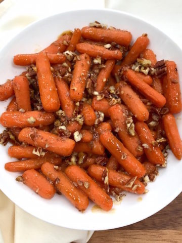 Glazed Spiced Baby Carrots with Pecans in serving bowl.
