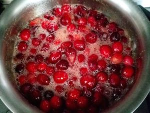 Cranberry sauce simmering in pan.