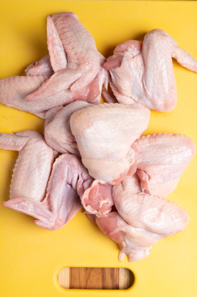 Fresh chicken wings on a cutting board.