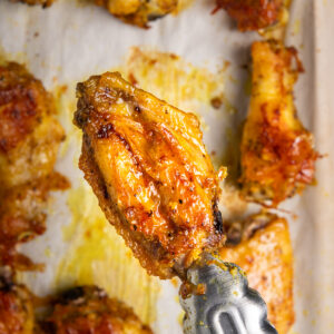 A golden adobo crack wing on a baking sheet.