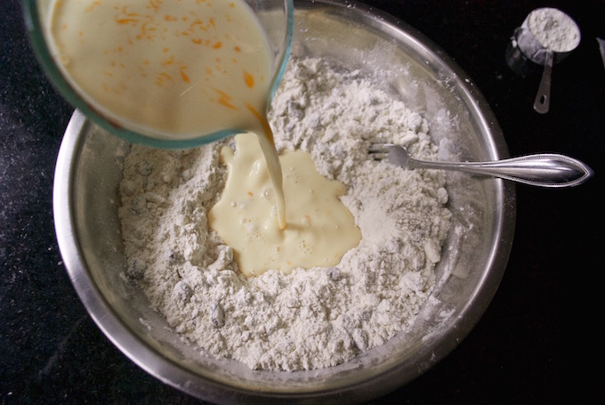 Adding milk and eggs to flour.