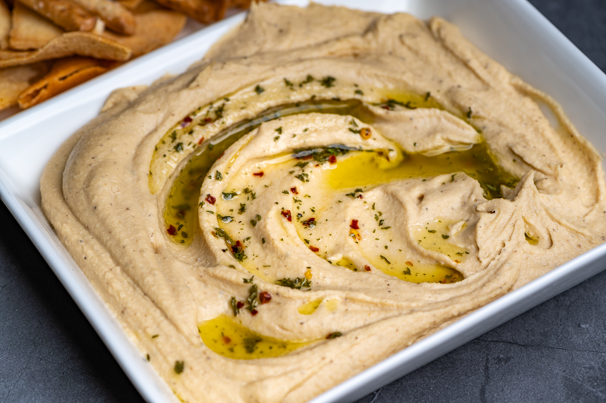 Hummus dressed with olive oil and spices on a platter.