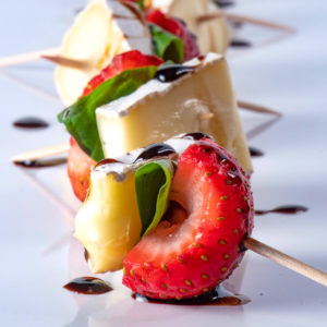 A skewer of strawberries, basil, and brie.