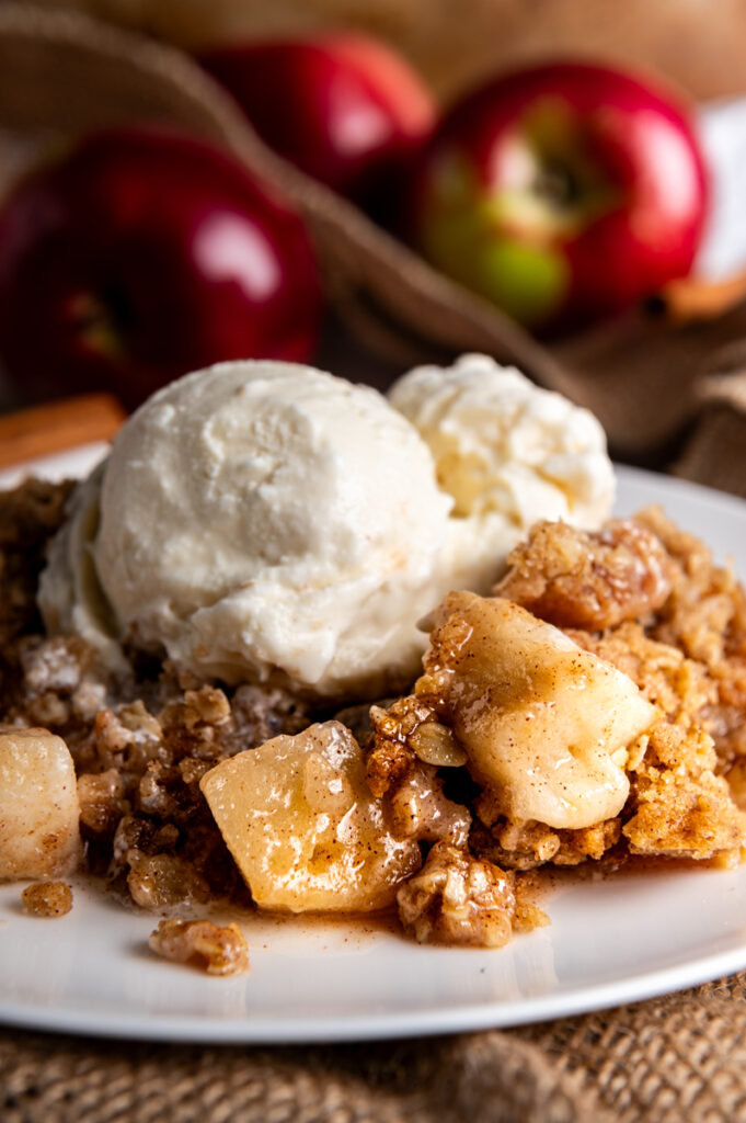 A serving of apple crisp with a scoop of vanilla ice cream.