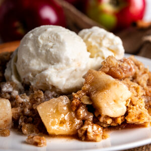 A serving of apple crisp with a scoop of vanilla ice cream.
