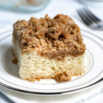 A slice of crumb coffee cake on a white plate.