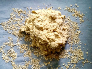 Scone dough on parchment scattered with oats.