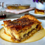 A slice of French toast casserole with maple syrup on a plate.