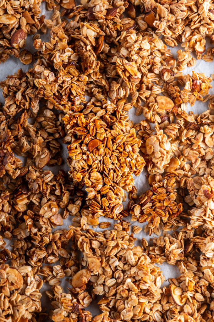 Clumps of homemade granola on a baking sheet.