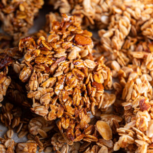 A large clump of homemade granola on a baking sheet.