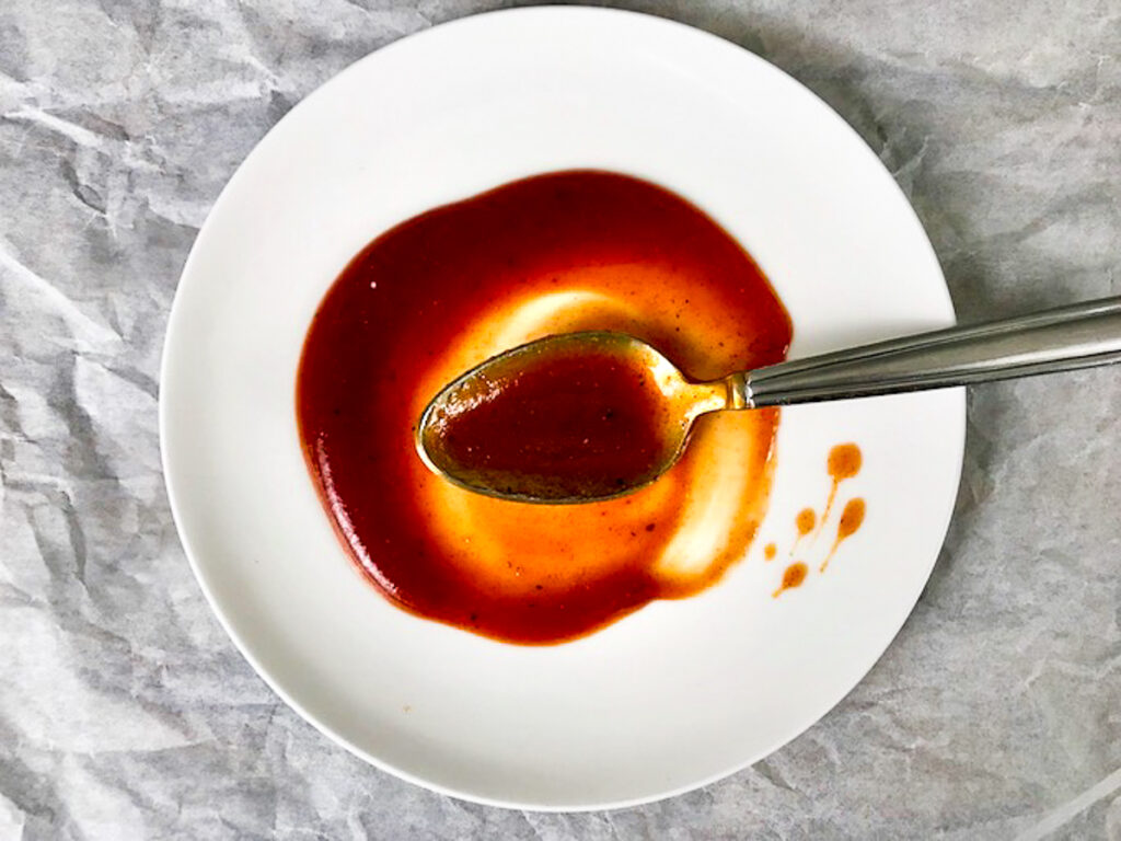 BBQ sauce on a plate with a spoon.