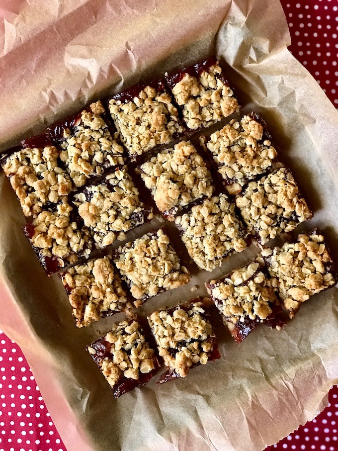 Sliced strawberry jam bars on parchment.