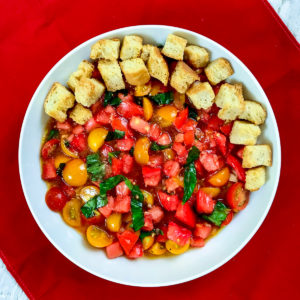 Tomato salad with toasted croutons on one side.