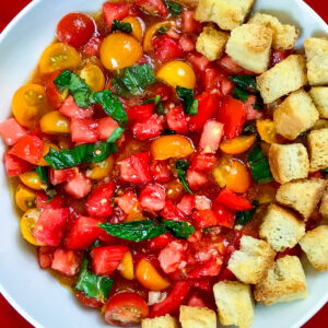 A round platter of tomato salad surrounded with croutons.