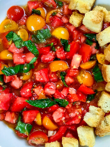 A round platter of tomato salad surrounded with croutons.