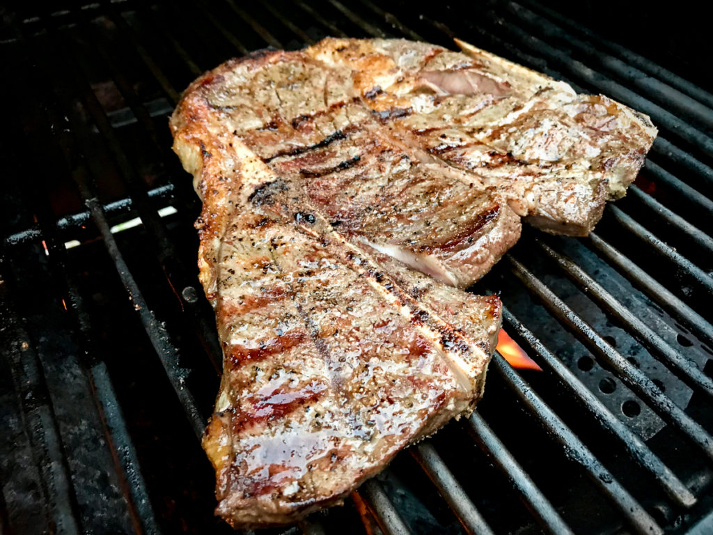 Flipping chuck steak on a grill.