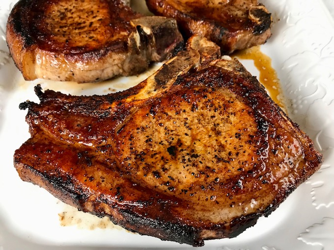 Pan seared pork chops on a platter.