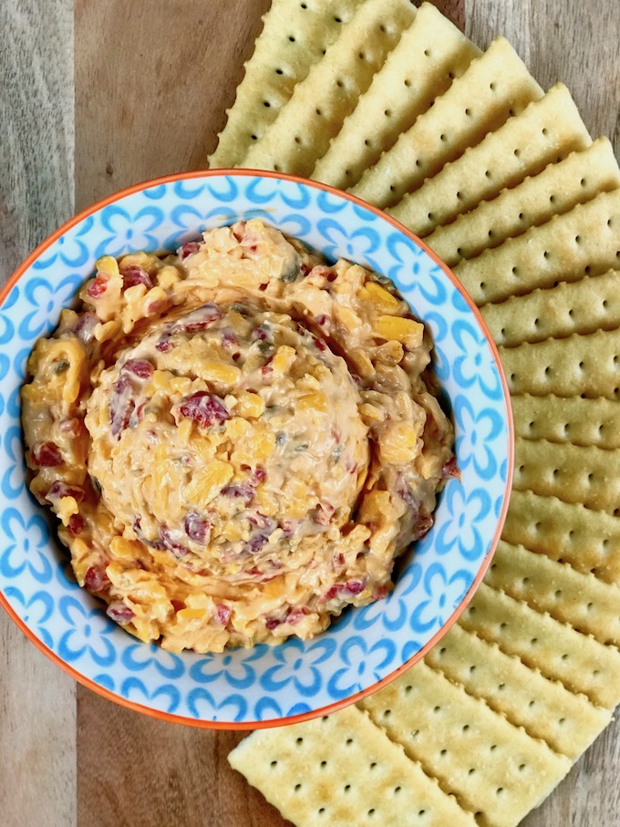 Pimento cheese in a bowl surrounded by crackers.
