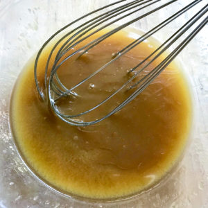 Whisking brown sugar and butter in a bowl.