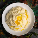 A white bowl of perfect mashed potatoes.