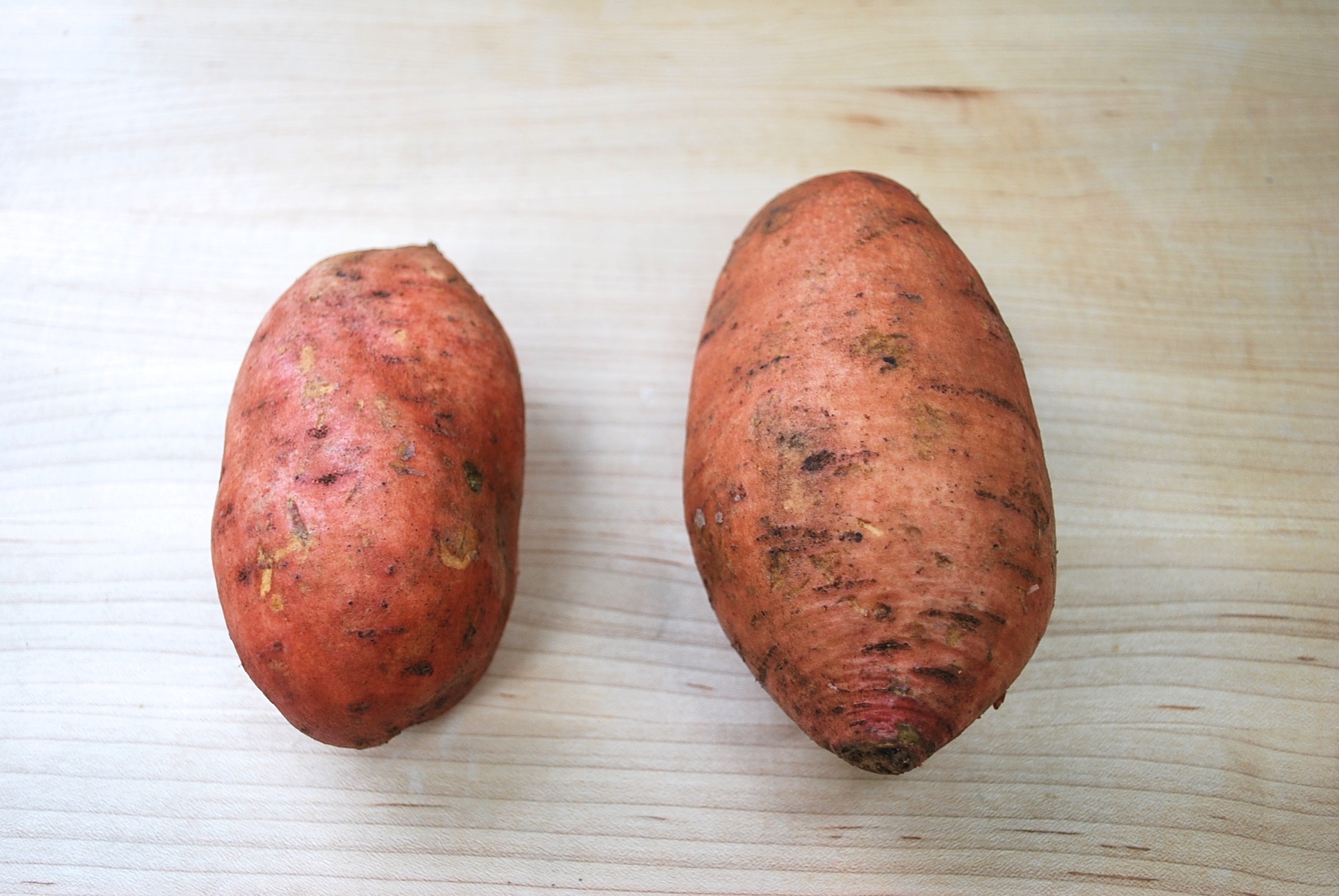 A small and large sweet potato.