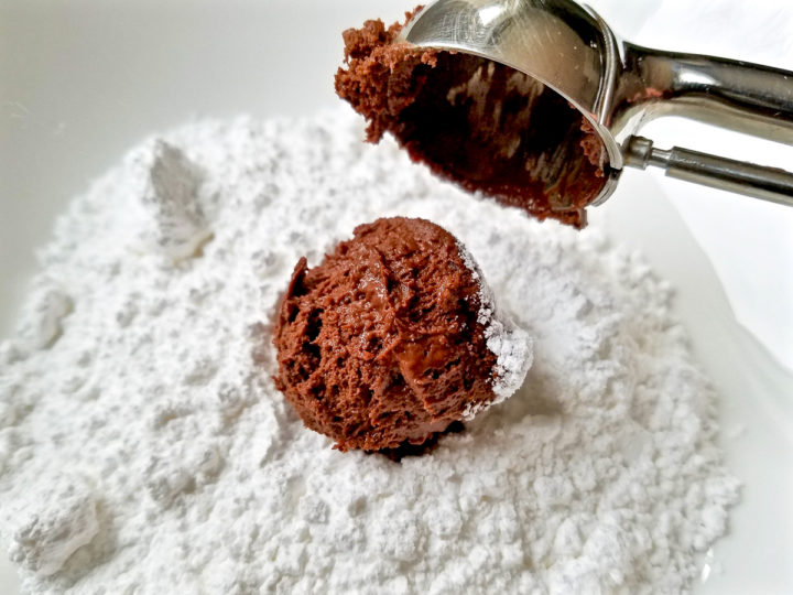 Rolling a ball of chocolate dough with powdered sugar.