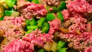 Browning the ground beef with peppers and onions.