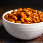 A white bowl of bourbon baked beans.