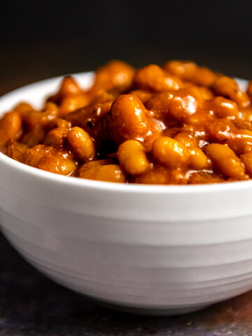 A white bowl of bourbon baked beans.