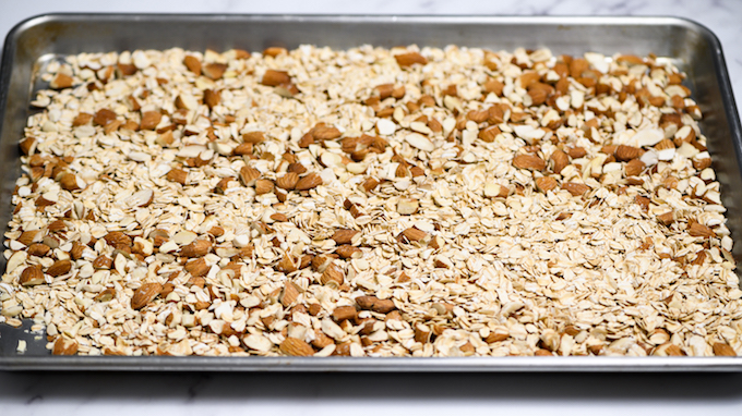 Oats and almonds on baking sheet.