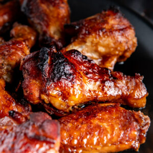 A roasted chicken wing covered in teriyaki sauce.