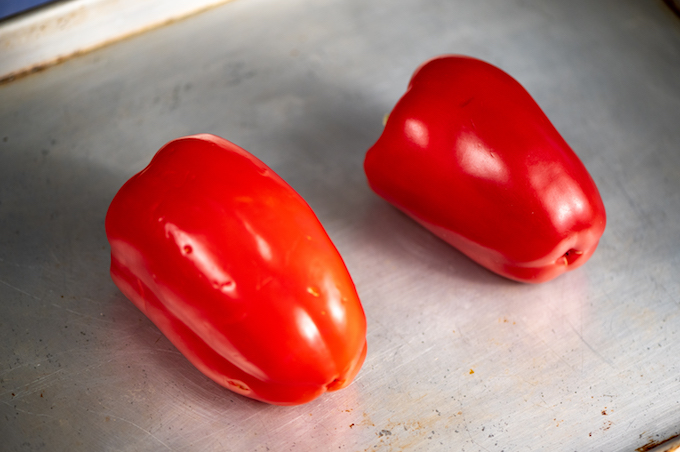 Red peppers on a baking sheet.