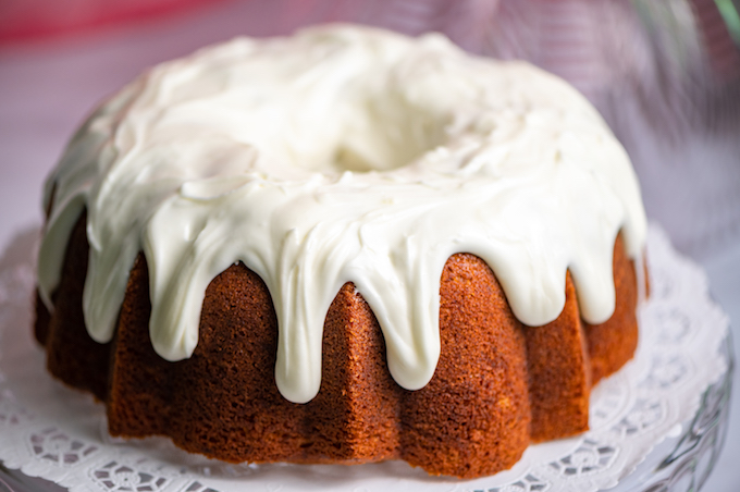 Banana bundt cake with cream cheese icing oozing down the sides.