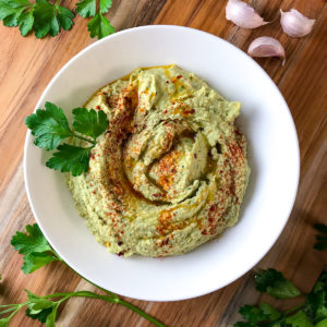 Parsley hummus in a white bowl.