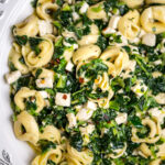 A bowl of spinach pasta salad.