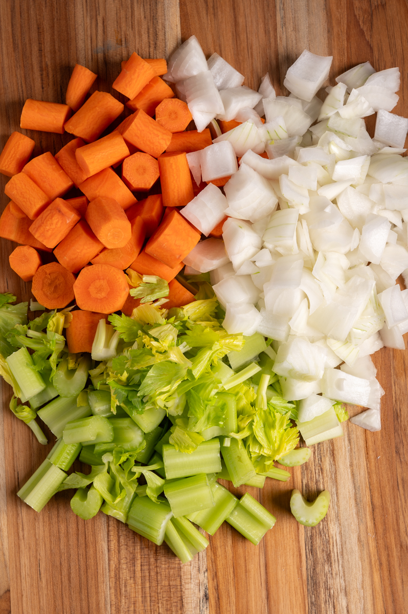 Chopped carrots, onions, and celery on a board.